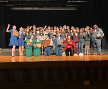  image of plano west speech and debate students on stage with awards.